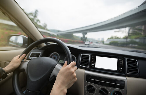 Image of a woman's hands driving a car